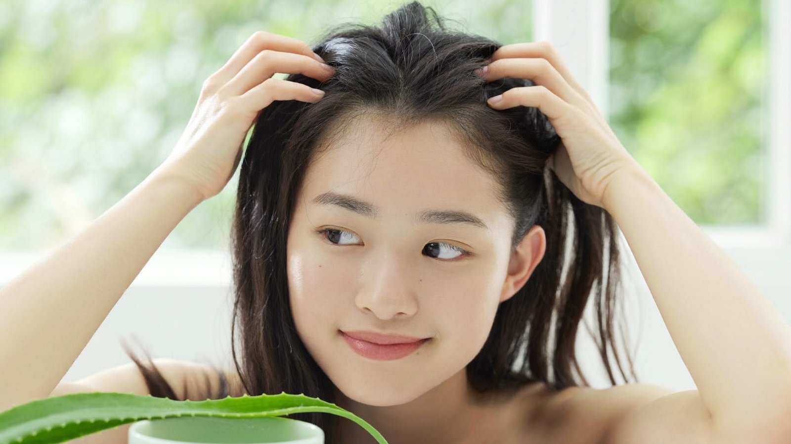 Người phụ nữ Á Đông nhẹ nhàng rẽ và massage da đầu, cảm giác thư giãn dịu nhẹ