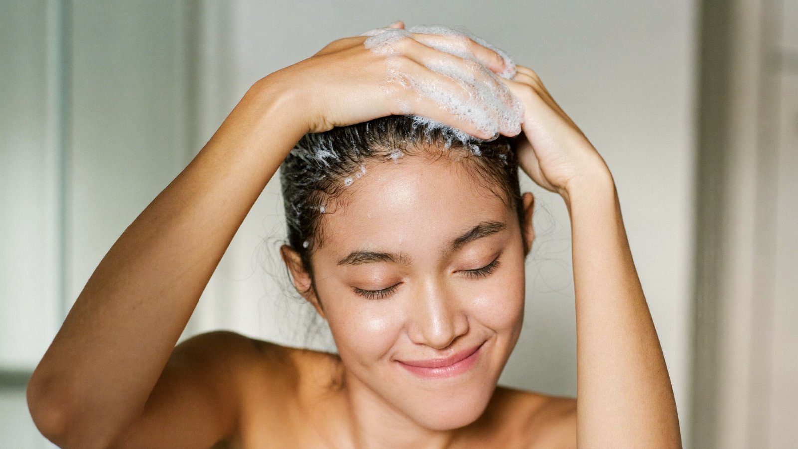 Cô gái gội đầu tạo bọt nhẹ, thư giãn khi làm quen dầu gội mới