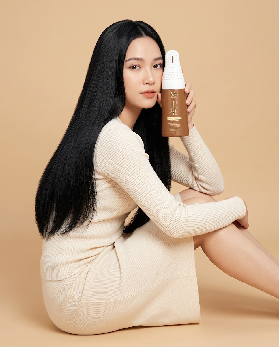 Cô gái Việt tóc dài ngồi cầm tinh chất dưỡng tóc M Natural 60ml