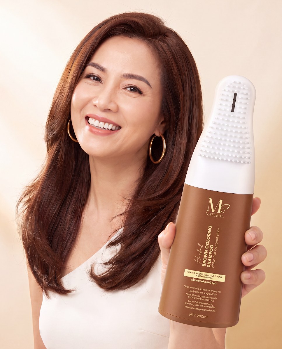 Phụ nữ trung niên tóc nâu cầm chai dầu gội nâu phủ bạc M Natural 200ml