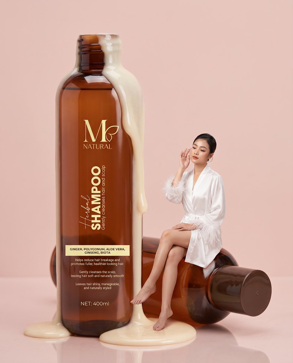 Chai dầu gội thảo dược M Natural 400ml bên người mẫu nữ, nền hồng pastel