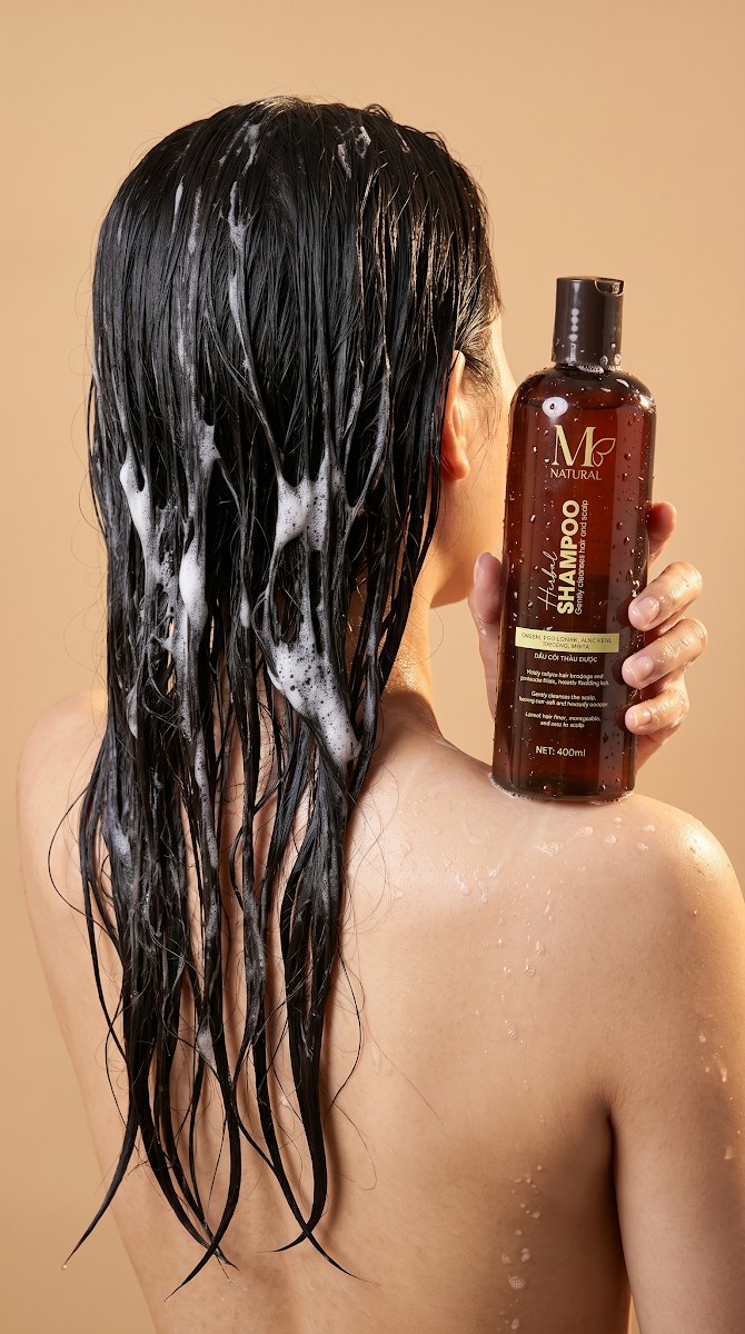Mái tóc dài ướt và chai dầu gội thảo dược M Natural 400ml