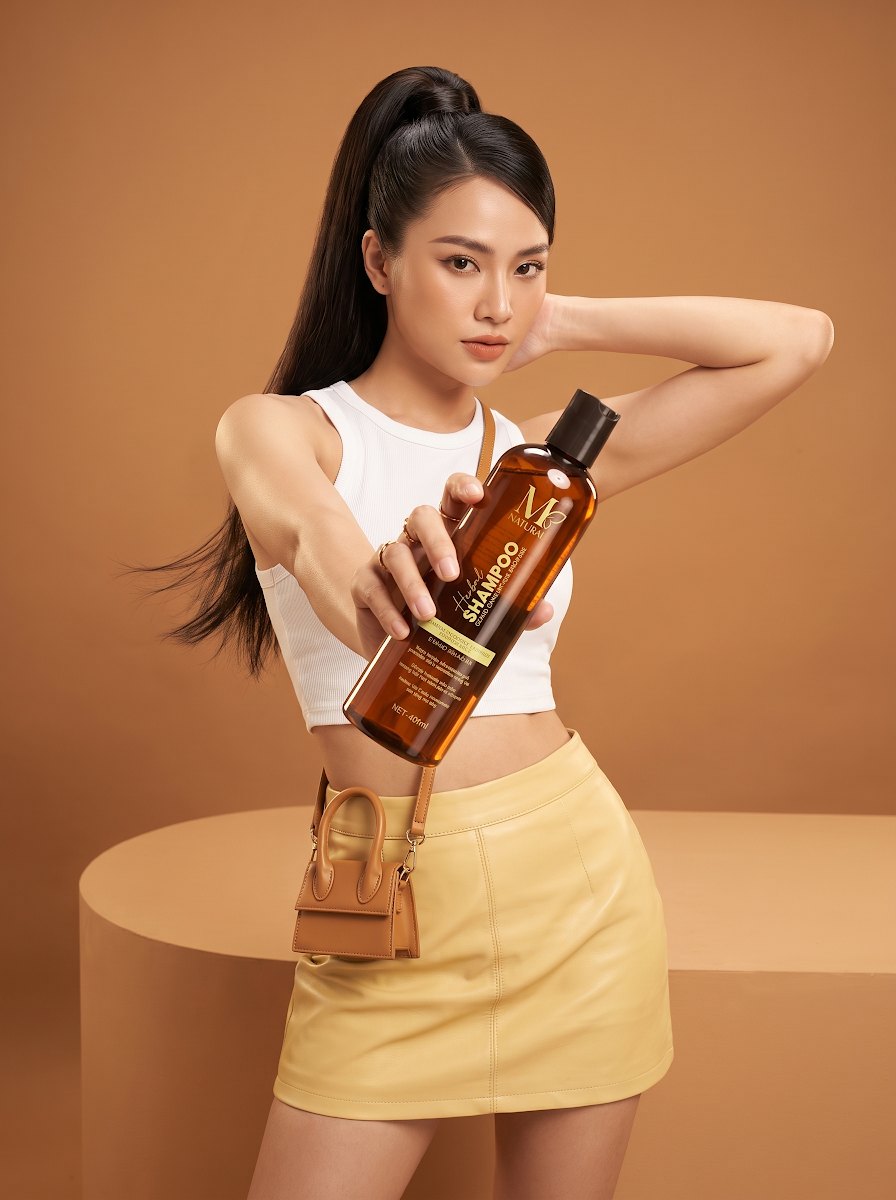 Cô gái Việt trẻ cầm chai dầu gội thảo dược M Natural 400ml