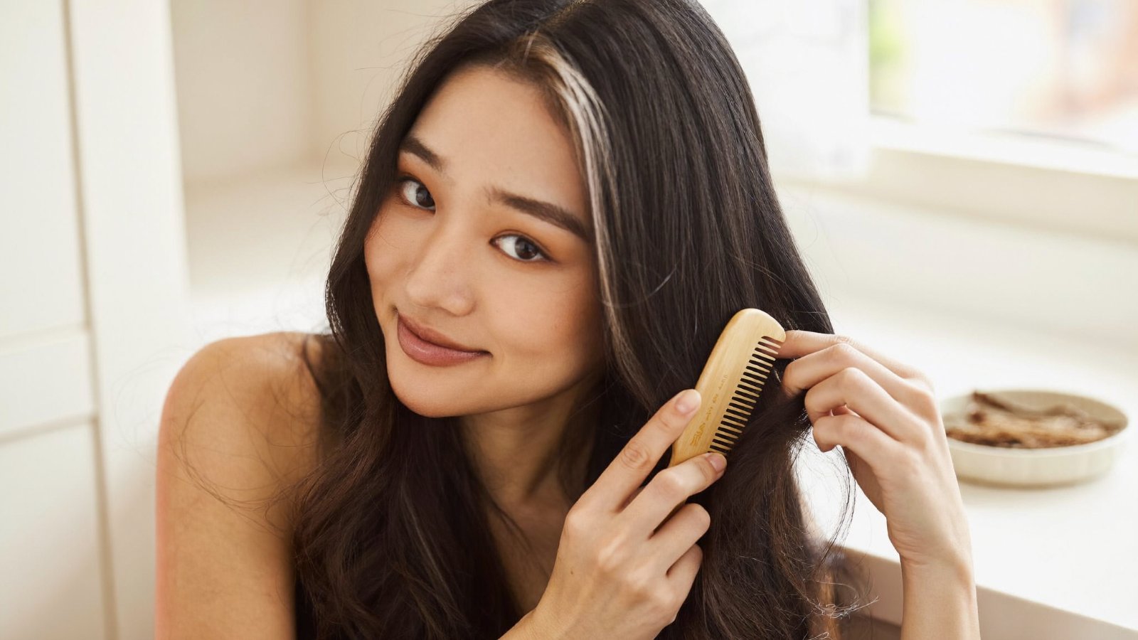 Cô gái chải mái tóc bằng lược gỗ, chăm sóc tóc điểm bạc nhẹ nhàng