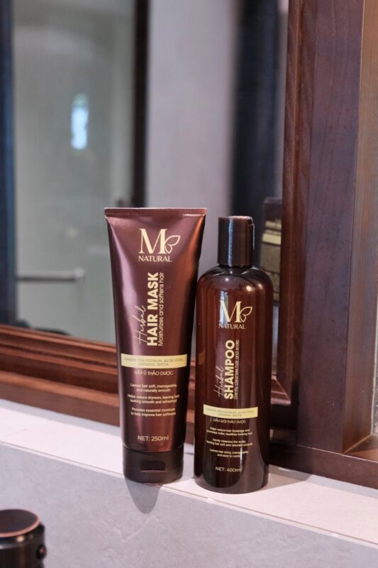 Tuýp kem hấp ủ và chai dầu gội M Natural trên bệ cửa sổ