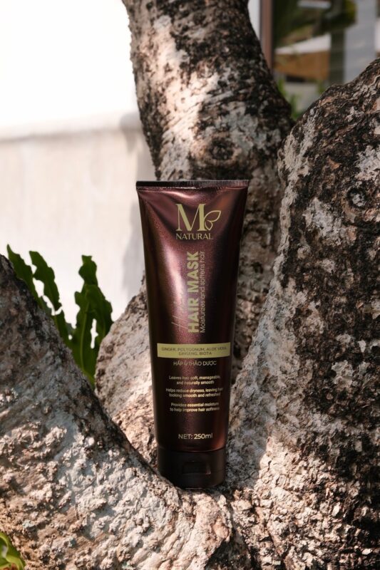 Tuýp kem hấp ủ M Natural tựa vào thân cây trong vườn