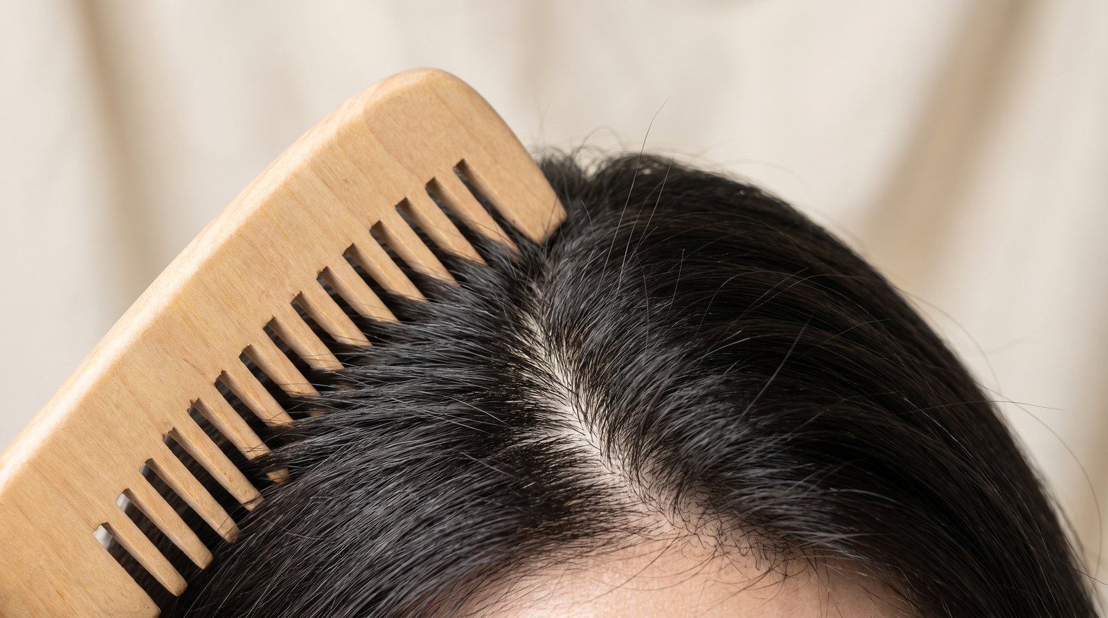 Lược gỗ rẽ chân tóc để lộ da đầu sạch, cận cảnh sợi tóc